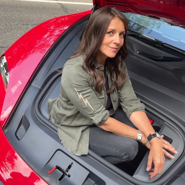 Ginny Buckley sitting in Porsche Taycan frunk 